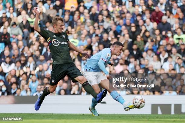 Phil Foden of Manchester City shoots under pressure from James Ward-Prowse of Southampton during the Premier League match between Manchester City and...