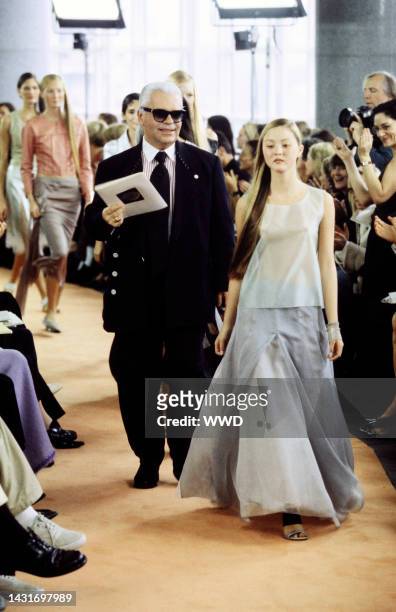 Designer Karl Lagerfeld walks the runway at the finale of the show, with model Devon Aoki.