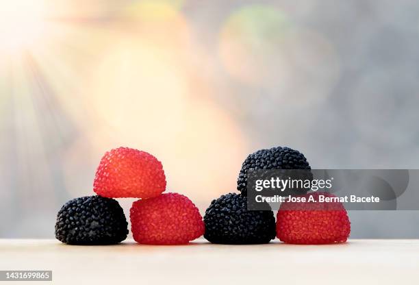 strawberry-shaped licorice soft candies illuminated by sunlight - polypodiaceae stock pictures, royalty-free photos & images