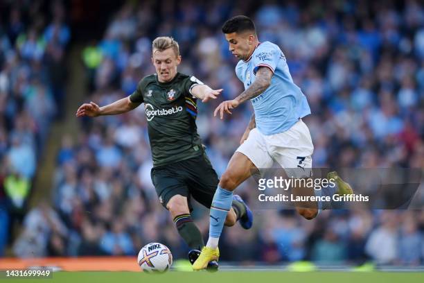 Joao Cancelo of Manchester City is challenged by James Ward-Prowse of Southampton during the Premier League match between Manchester City and...