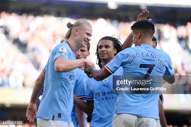 Erling Haaland celebrates with Joao Cancelo and Nathan Ake of Manchester City after scoring their team's fourth goal during the Premier League match...