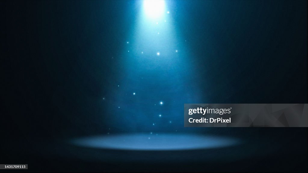 Blue Spotlight with Particles Illuminating the Stage