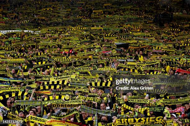 Borussia Dortmund fans show their support in the 'Yellow Wall' with scarves prior to the Bundesliga match between Borussia Dortmund and FC Bayern...