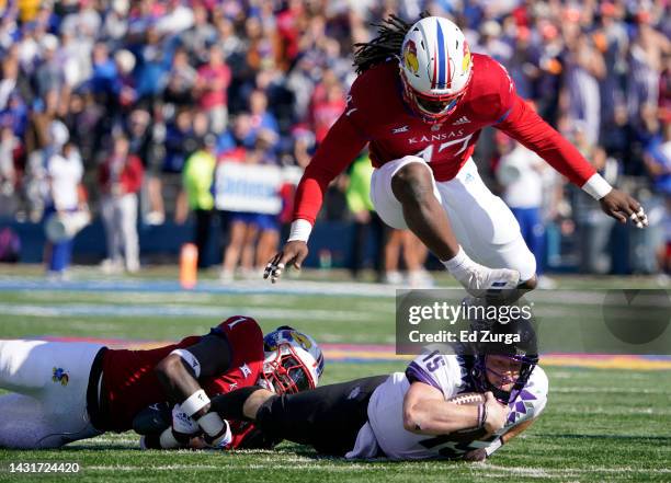 Quarterback Max Duggan of the TCU Horned Frogs is tackled by safety Kenny Logan Jr. #1 and defensive end Lonnie Phelps of the Kansas Jayhawks in the...