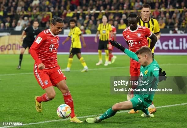 Leroy Sane of Bayern Munich runs with the ball from Alexander Meyer of Borussia Dortmund during the Bundesliga match between Borussia Dortmund and FC...