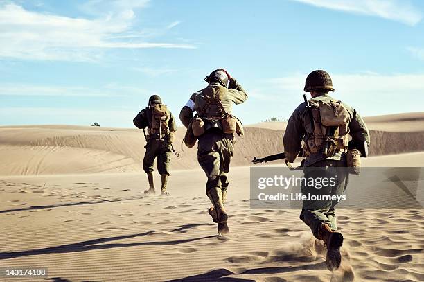 tre soldati della seconda guerra mondiale in esecuzione nella sabbia del deserto - seconda guerra mondiale foto e immagini stock