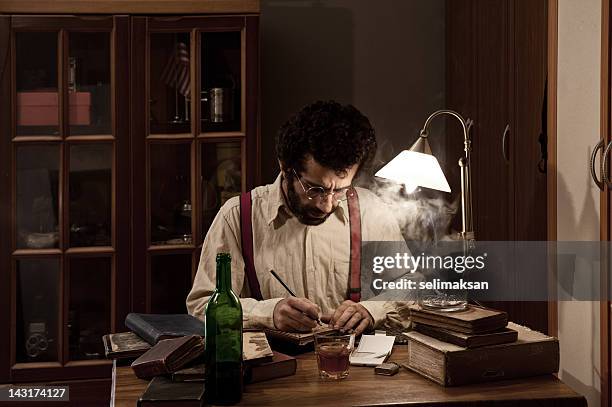 poet writing on table in the dark - author holding book stock pictures, royalty-free photos & images