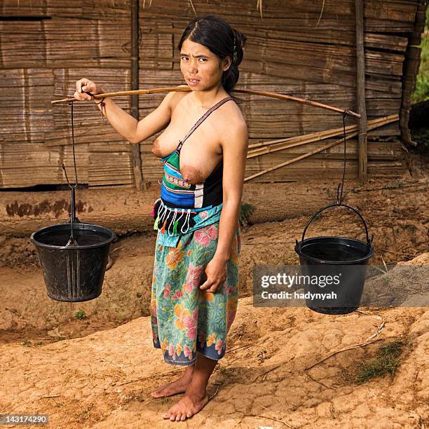 young akha woman carrying water in northern laos - akha woman stock pictures, royalty-free photos & images