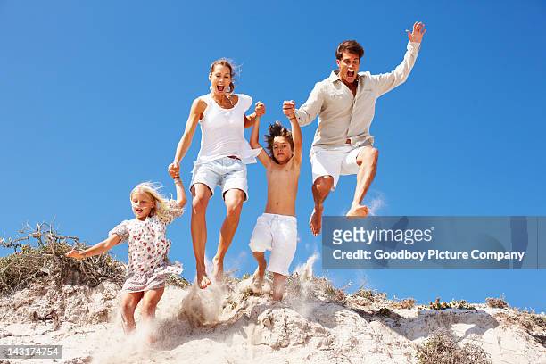 taking the leap together! - beach family jumping stock pictures, royalty-free photos & images