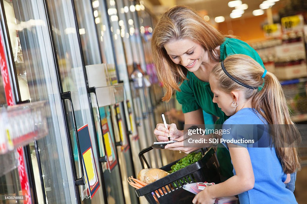 Mutter und Tochter, die Einkaufsliste im Supermarkt