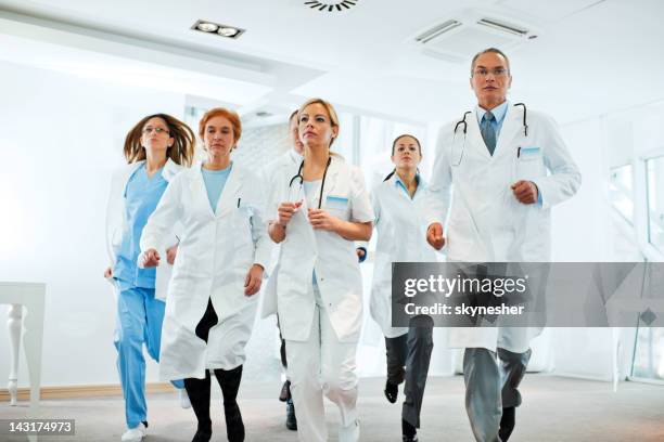 serious group of doctors running - emergency department stock pictures, royalty-free photos & images