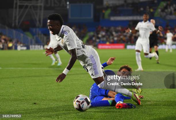 Vinicius Junior of Real Madrid is tackled by Luis Milla of Getafe CF during the LaLiga Santander match between Getafe CF and Real Madrid CF at...