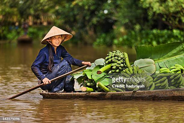 mulher vietnamita remo de barco no rio mekong delta, vietnam - vietnam imagens e fotografias de stock