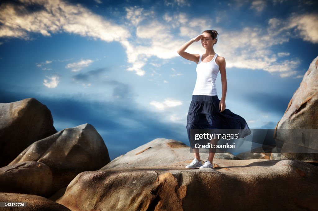 Girl Looking Over Rocks Girl Stands On Huge Rocks And Stares Into The Distance High-Res Stock ...