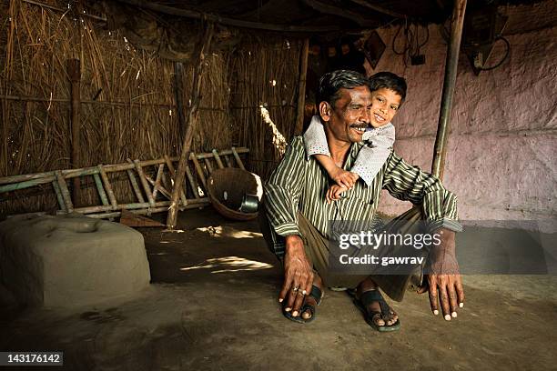 real people from rural india: happy father and son - hut interior stock pictures, royalty-free photos & images