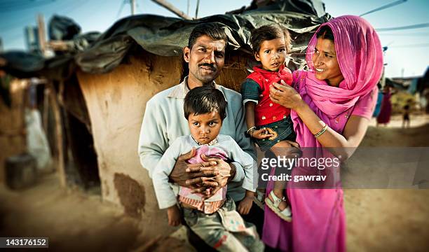 real people from rural india: happy parents with their children. - four people stock pictures, royalty-free photos & images