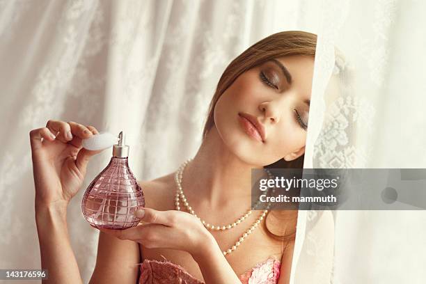 young woman applying perfume - perfume sprayer stock pictures, royalty-free photos & images