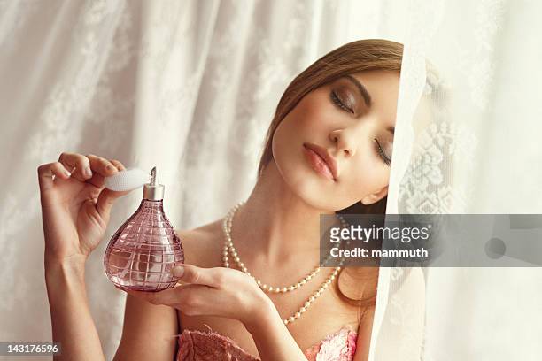 young woman applying perfume - 香水 個照片及圖片檔