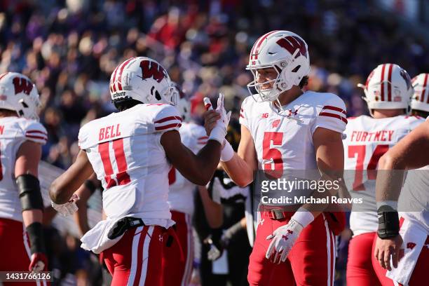 Skyler Bell of the Wisconsin Badgers celebrates a touchdown with Graham Mertz against the Northwestern Wildcats during the first half at Ryan Field...