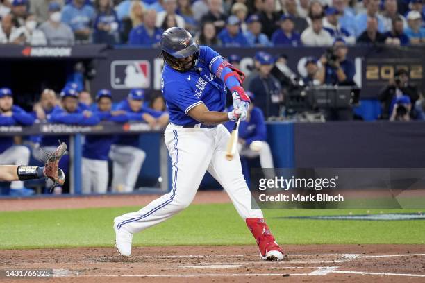 Vladimir Guerrero Jr. #27 of the Toronto Blue Jays hits a single to center field to score Santiago Espinal against Robbie Ray of the Seattle Mariners...