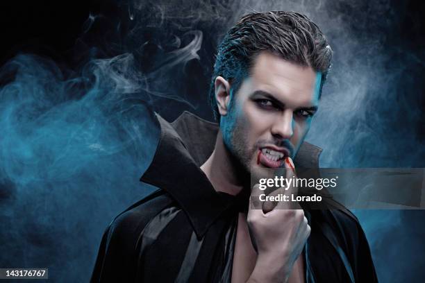 vampiro probar la sangre, desde su dedo - vampiro fotografías e imágenes de stock