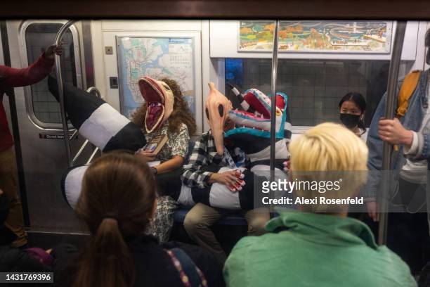 People dressed as Adam and Barbara Maitland from "Beetlejuice" ride the subway after leaving New York Comic Con 2022 on October 08, 2022 in New York...