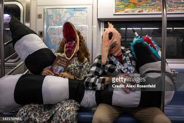 People dressed as Adam and Barbara Maitland from "Beetlejuice" ride the subway after leaving New York Comic Con 2022 on October 08, 2022 in New York...