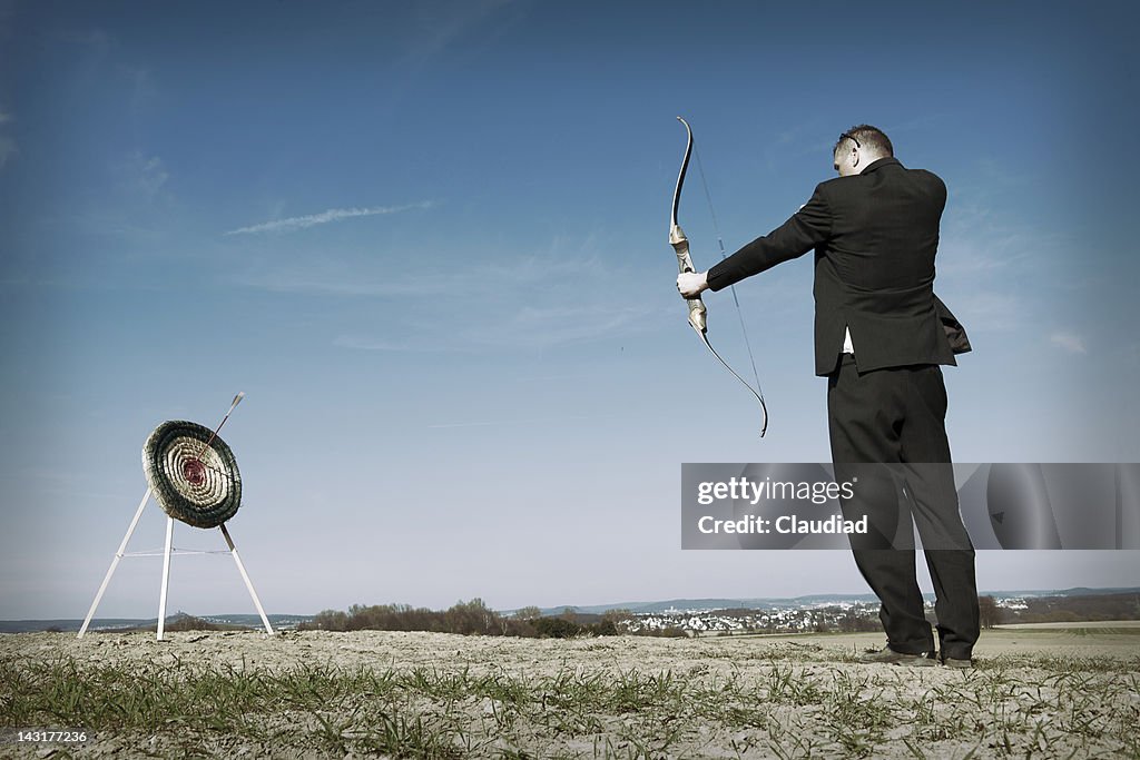 Businessman shooting on target