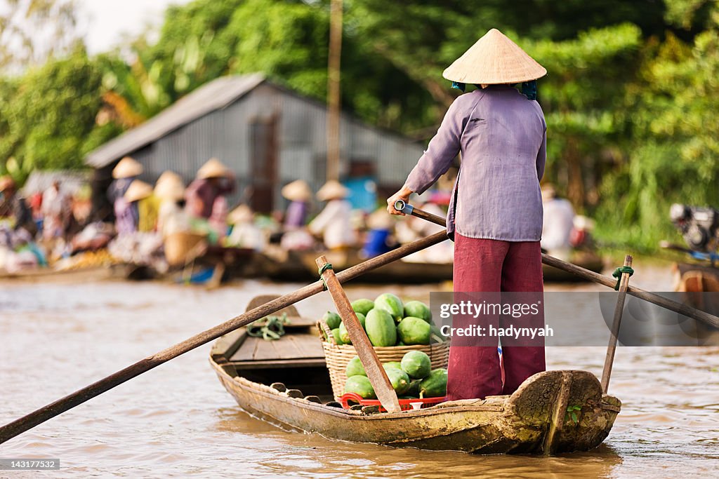 Vietnamese woman rowing boat in the Mekong River Delta, Vietnam