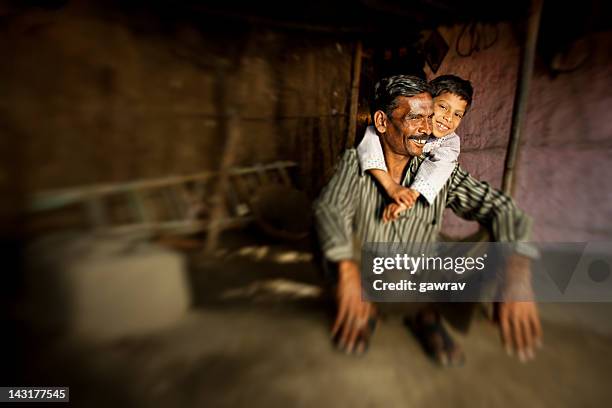 real people from rural india: happy father and son - indian slums stock pictures, royalty-free photos & images