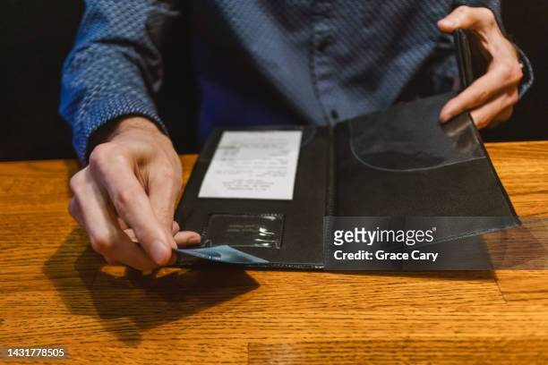man pays restaurant bill with credit card - restaurant bill stock pictures, royalty-free photos & images