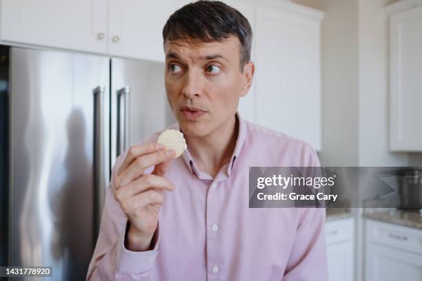 man snacks on potato chips and dip - people eating chips and dip photos et images de collection