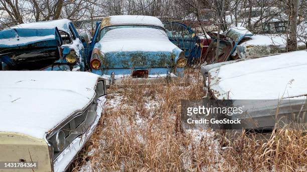 a group of old cars left to rot in a field - stock photo car chrome bumper stock-fotos und bilder
