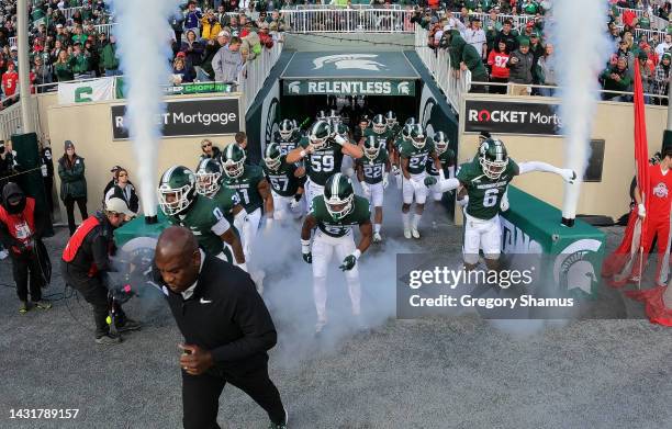 Head coach Mel Tucker of the Michigan State Spartans leads his team onto the field to play the Ohio State Buckeyes at Spartan Stadium on October 08,...