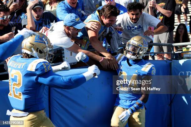 Grayson Murphy congratulates Jaylin Davies of the UCLA Bruins after his fumble recovery during the second half of a game against the Utah Utes at the...