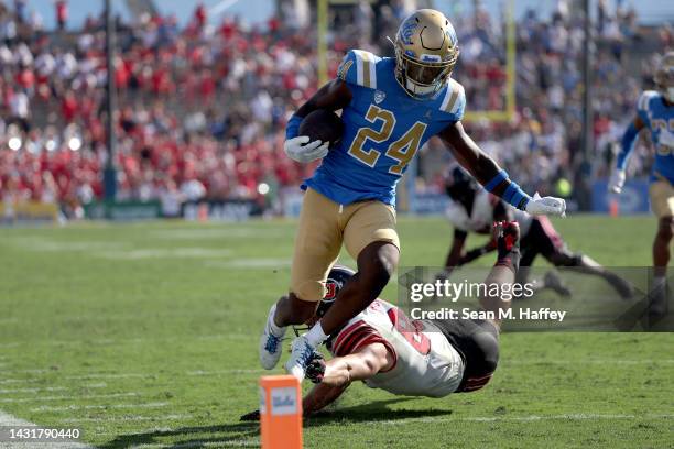 Jaylin Davies of the UCLA Bruins eludes the tackle of Dalton Kincaid of the Utah Utes after a fumble recovery during the second half of a game at the...