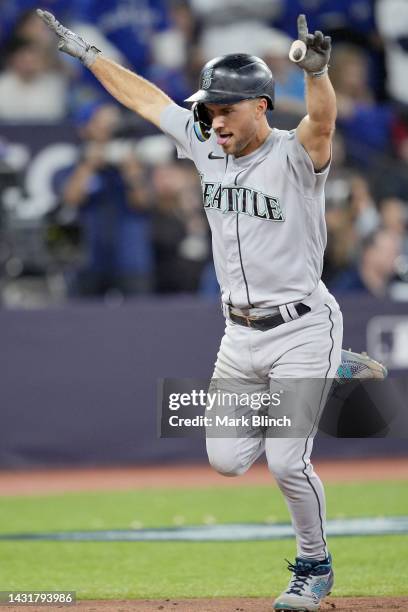 Mitch Haniger of the Seattle Mariners celebrates after scoring on a double hit by J.P. Crawford against the Toronto Blue Jays during the eighth...