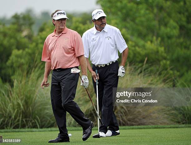 Bob Gilder and Eduardo Romero of Argentina watch a tee shot o the 4th hole during the first round of the Legends Division at the Liberty Mutual...