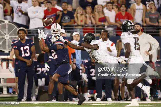 Wide receiver Jacob Cowing of the Arizona Wildcats catches a 37-yard reception past defensive back Trikweze Bridges of the Oregon Ducks during the...