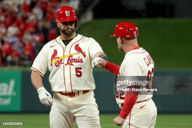 Albert Pujols of the St. Louis Cardinals celebrates with Stubby Clapp after hitting a single to left field against the Philadelphia Phillies during...