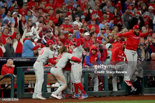 Edmundo Sosa of the Philadelphia Phillies celebrates with Matt Vierling and Alec Bohm after catching a foul ball to end the ninth inning and defeat...