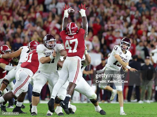 Haynes King of the Texas A&M Aggies passes through the hands of Byron Young of the Alabama Crimson Tide during the second half at Bryant-Denny...