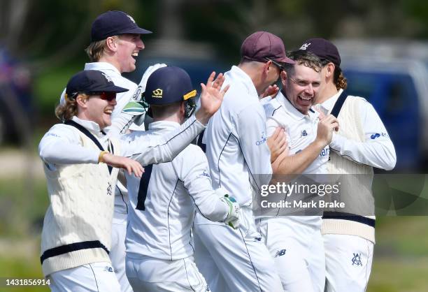 Jon Holland of the Bushrangers celebrates the wicket of Nathan McSweeney of the Redbacks hugged by team mates during the Sheffield Shield match...
