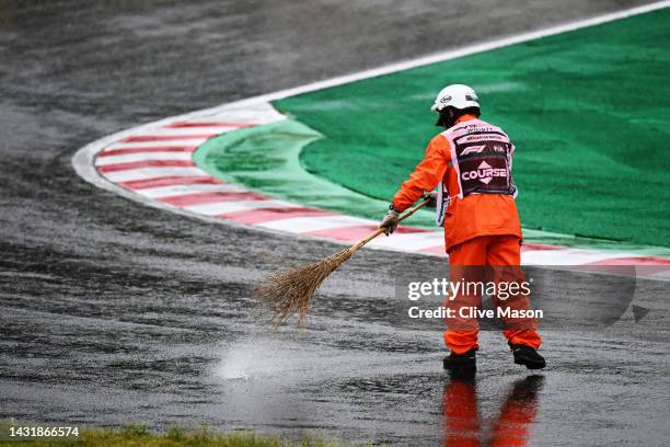 Track marshal clears rain water from the circuit during a red flag delay during the F1 Grand Prix of Japan at Suzuka International Racing Course on...