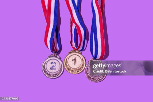 gold, silver and bronze medal, with the numbers 1, 2 and 3, on a purple background. concept of winner, olympic podium, medals, honor, women's day, winning woman, working woman and sports competition. - concurso fotografías e imágenes de stock