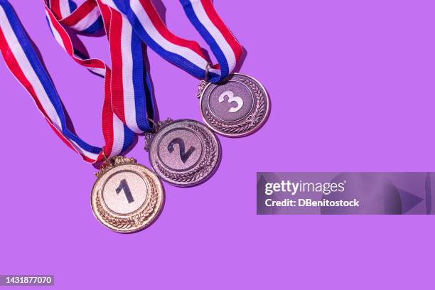 gold, silver and bronze medal, with the numbers 1, 2 and 3, on a purple background. concept of winner, olympic podium, medals, honor, women's day, winning woman, working woman and sports competition. - silver medal with ribbon stock pictures, royalty-free photos & images