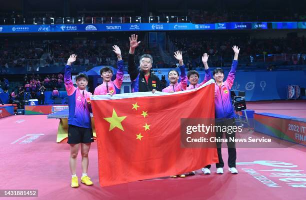 Sun Yingsha, Wang Manyu, coach Li Sun, Chen Meng, Wang Yidi and Chen Xingtong of China celebrate with a Chinese national flag after winning the...