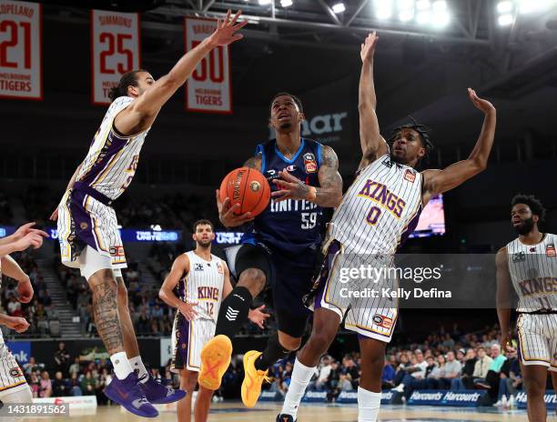 Rayjon Tucker of United drives to the basket against Xavier Cooks of the Kings and Justin Simon of the Kings during the round two NBL match between...