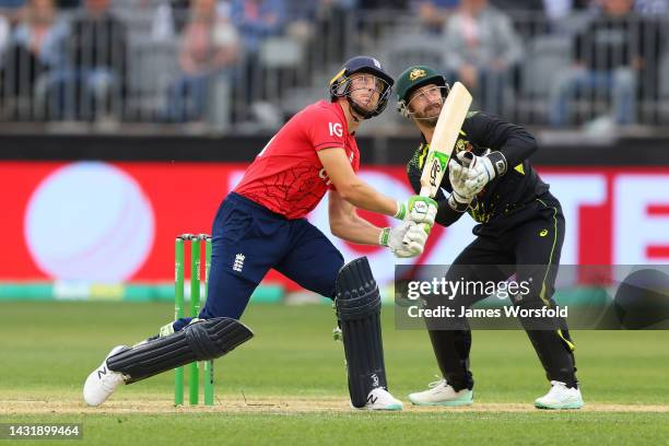 Jos Buttler of England and Matthew Wade of Australia watch the ball go for six during game one of the T20 International series between Australia and...