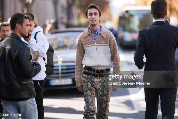 Mattia Stanga seen wearing full Miu Miu look, brown and beige cardigan, blue blouse, snake printed pants with two belts, outside Miu Miu during...